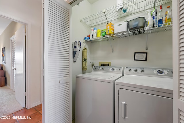 laundry room with laundry area, light carpet, washing machine and clothes dryer, and light tile patterned floors