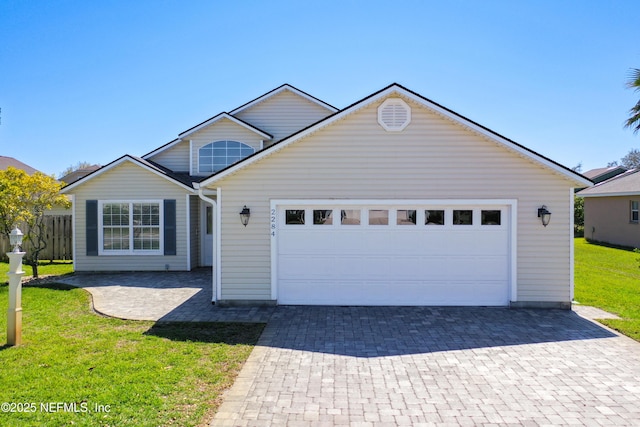 view of front facade with an attached garage, decorative driveway, and a front lawn