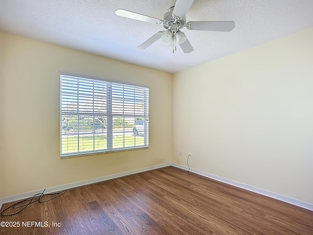 unfurnished room with baseboards, a textured ceiling, wood finished floors, and a ceiling fan