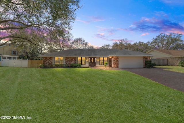 view of front of property with a garage, brick siding, fence, driveway, and a front yard