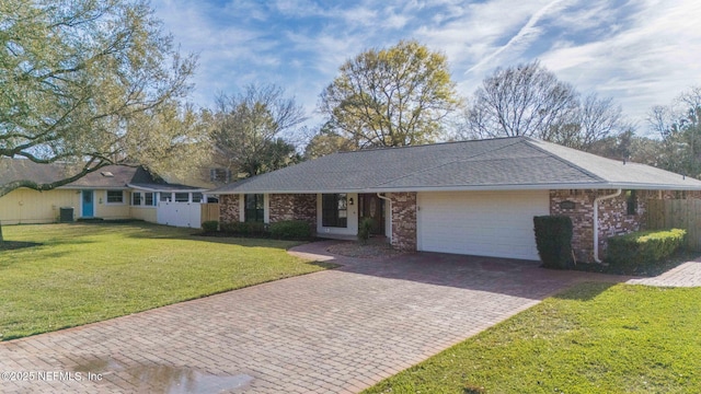 ranch-style house with a garage, a shingled roof, decorative driveway, a front lawn, and brick siding