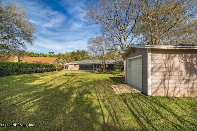 view of yard with driveway, a detached garage, and an outdoor structure