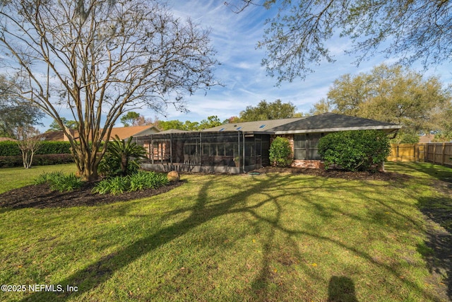 view of yard with a sunroom and fence