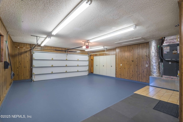 garage featuring a garage door opener and wooden walls