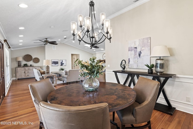 dining area featuring lofted ceiling, ceiling fan, ornamental molding, and wood finished floors