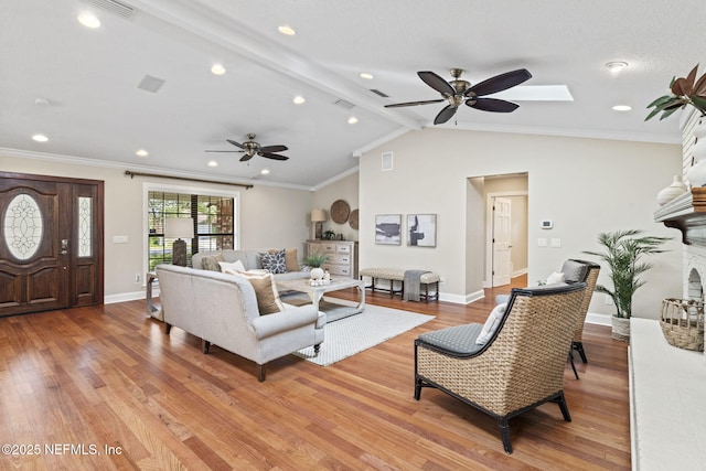 living room featuring lofted ceiling with beams, visible vents, light wood-style flooring, and baseboards