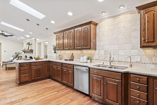 kitchen with tasteful backsplash, ornamental molding, a peninsula, stainless steel dishwasher, and a sink