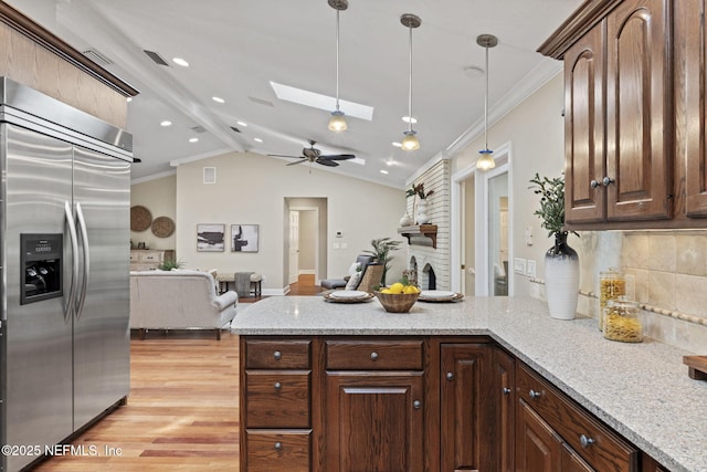 kitchen featuring a peninsula, light wood finished floors, crown molding, and built in fridge