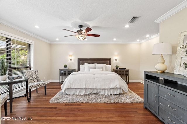 bedroom with dark wood-style floors, ornamental molding, a textured ceiling, and baseboards