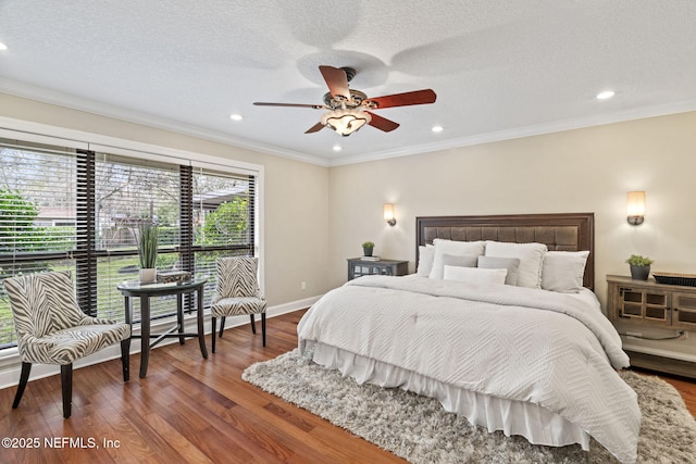 bedroom featuring a textured ceiling, recessed lighting, wood finished floors, baseboards, and crown molding