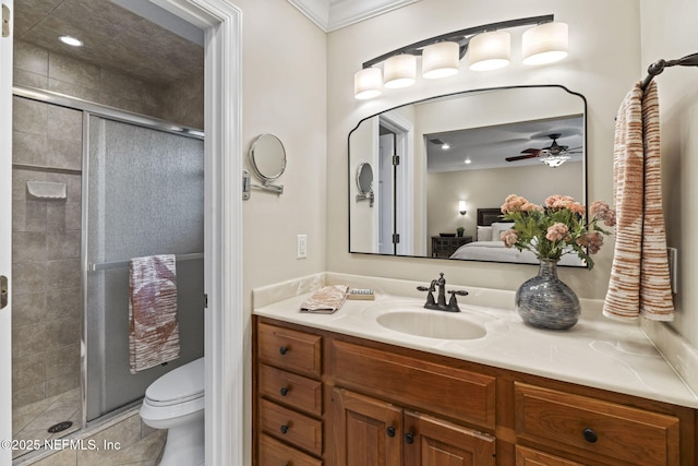 ensuite bathroom with ensuite bathroom, ceiling fan, toilet, vanity, and a stall shower