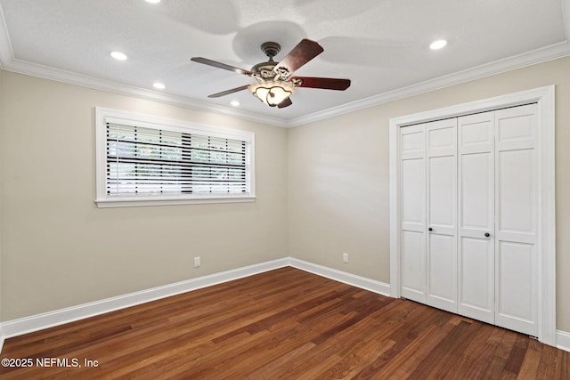 unfurnished bedroom featuring baseboards, a closet, ornamental molding, and wood finished floors