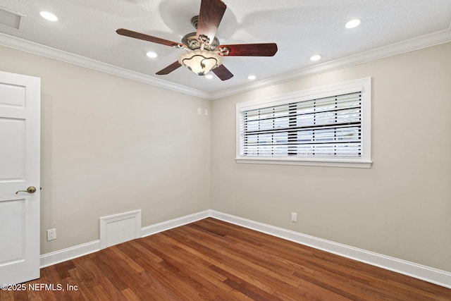 spare room with visible vents, wood finished floors, and ornamental molding