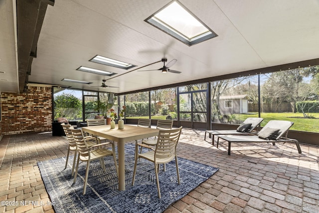 sunroom with a ceiling fan, a skylight, and a wealth of natural light