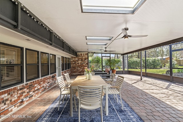 unfurnished sunroom featuring a skylight and a ceiling fan