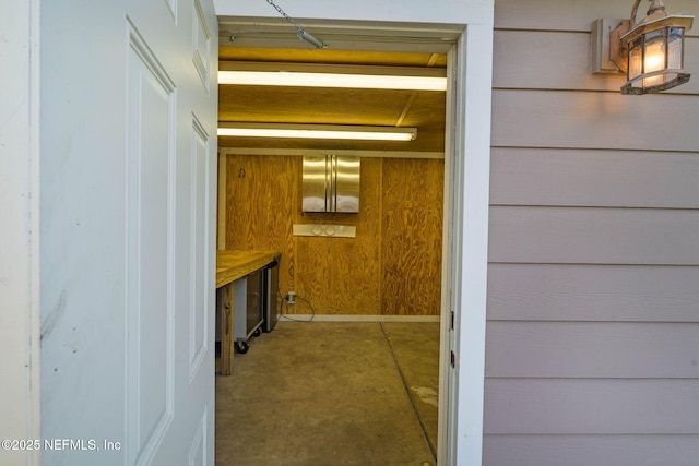 hall with wooden walls and concrete flooring