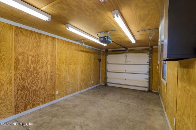 garage featuring wood walls and a garage door opener