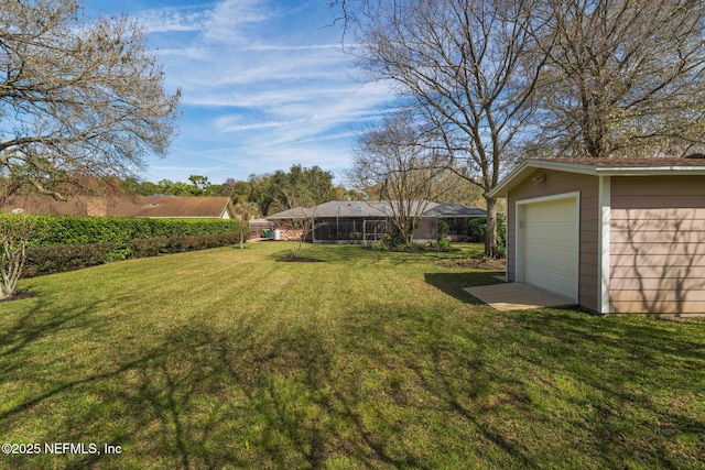 view of yard with a garage, driveway, and an outdoor structure