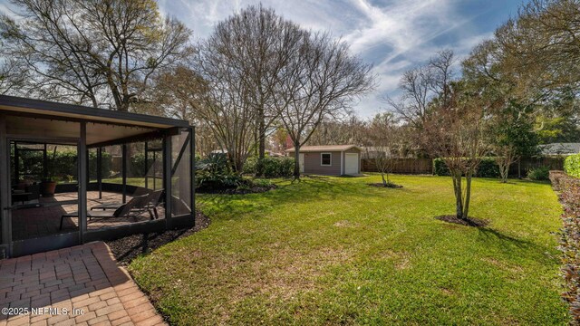 view of yard with a shed, fence, an outdoor structure, and a patio