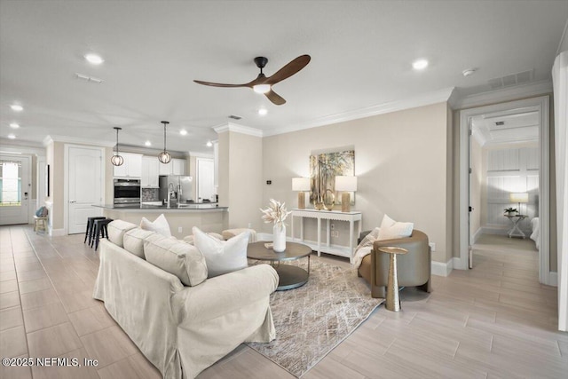 living area with ceiling fan, ornamental molding, visible vents, and recessed lighting