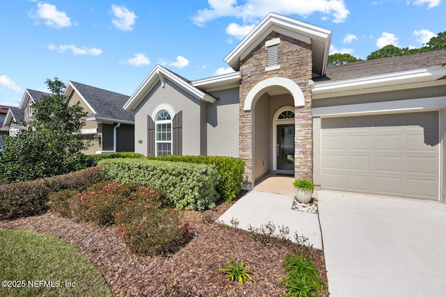 view of front facade featuring an attached garage, stone siding, and stucco siding