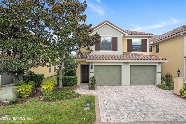 view of front of property with a tiled roof, decorative driveway, and stucco siding