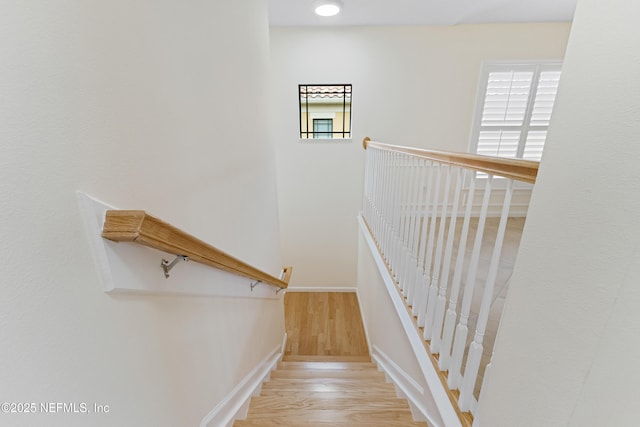 staircase with baseboards and wood finished floors