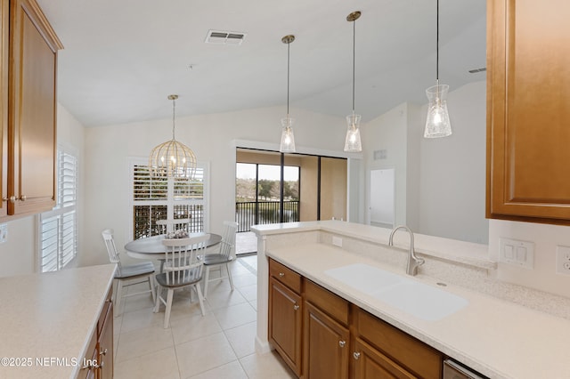 kitchen with light countertops, a sink, visible vents, and brown cabinets