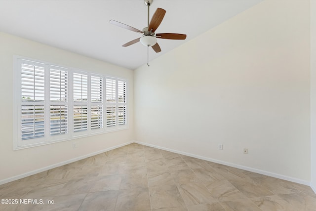 spare room with baseboards, vaulted ceiling, and a ceiling fan