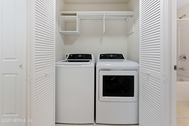 clothes washing area featuring laundry area, washing machine and clothes dryer, and tile patterned floors