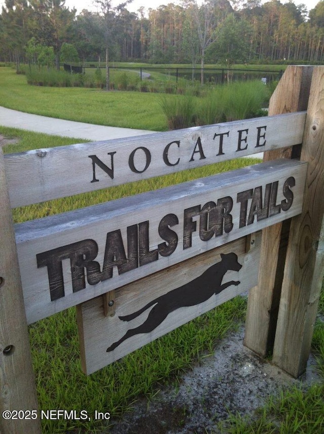 community / neighborhood sign with a wooded view