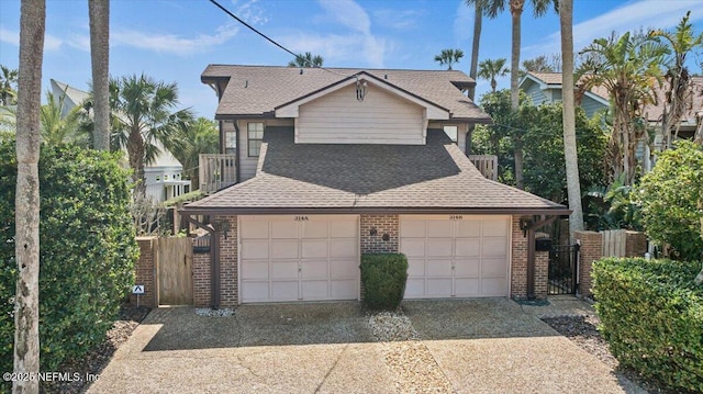 view of front of house with a garage, brick siding, fence, and roof with shingles