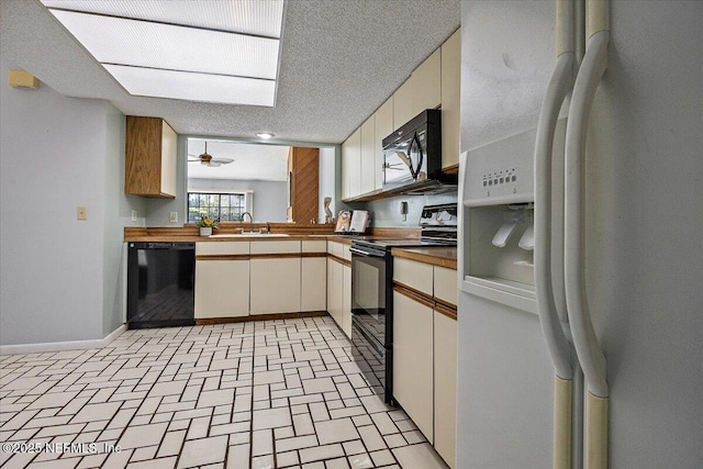 kitchen featuring baseboards, ceiling fan, a textured ceiling, black appliances, and a sink