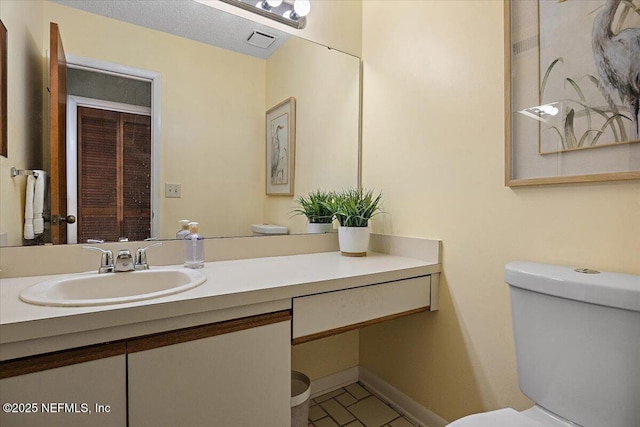 bathroom with toilet, baseboards, visible vents, and vanity