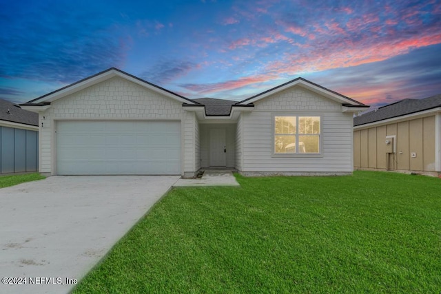 ranch-style house with a garage, concrete driveway, and a front lawn