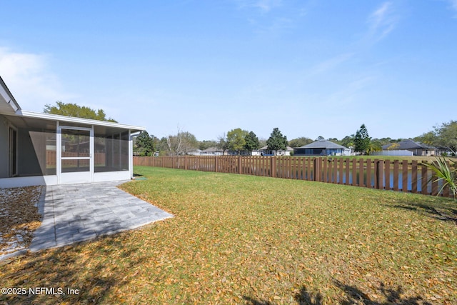 view of yard featuring a sunroom, a fenced backyard, and a patio