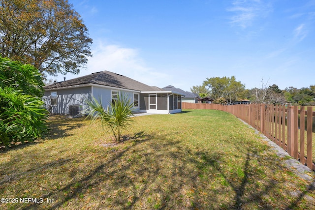 view of yard with cooling unit, a sunroom, and a fenced backyard