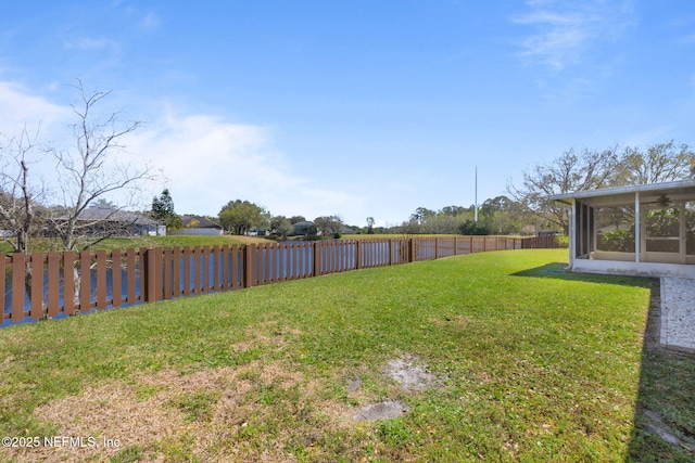 view of yard featuring a sunroom and a fenced backyard