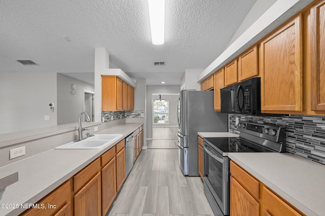 kitchen featuring appliances with stainless steel finishes, light countertops, visible vents, and a sink