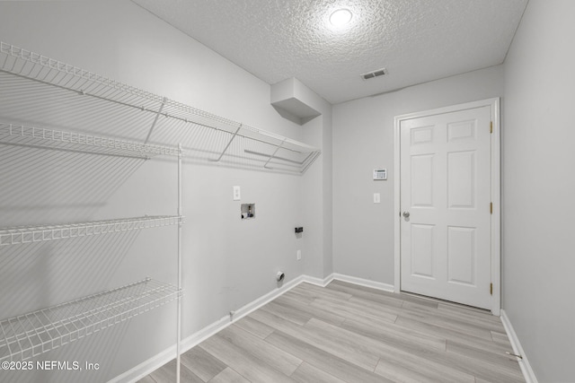 laundry room featuring laundry area, visible vents, hookup for an electric dryer, light wood-style floors, and washer hookup