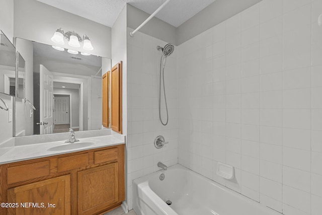 bathroom featuring shower / bathtub combination, a textured ceiling, and vanity