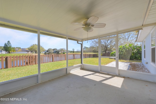 unfurnished sunroom featuring a ceiling fan