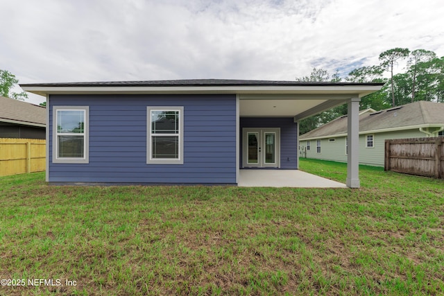 rear view of house featuring a yard, french doors, a patio area, and fence