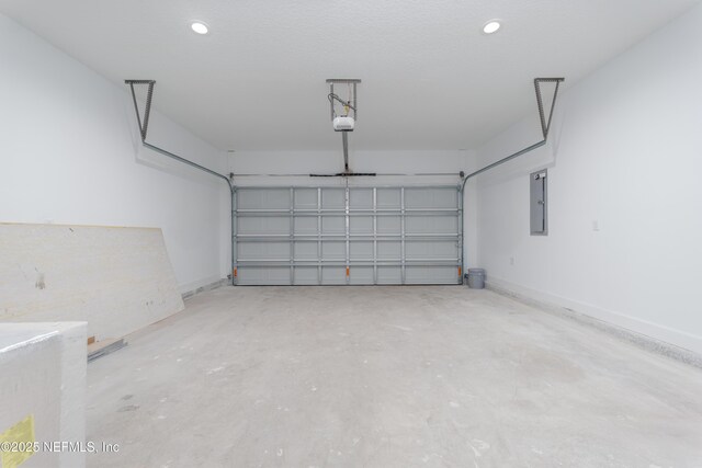 garage featuring recessed lighting, electric panel, baseboards, and a garage door opener