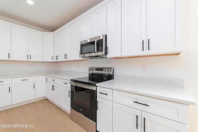 kitchen featuring light stone counters, stainless steel appliances, recessed lighting, light wood-style flooring, and white cabinets