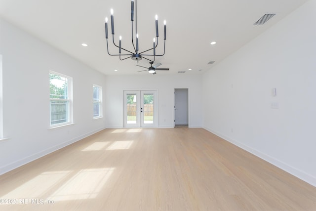 unfurnished living room featuring light wood-style floors, french doors, visible vents, and baseboards