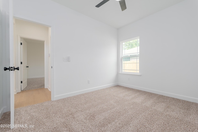 spare room featuring light carpet, ceiling fan, and baseboards