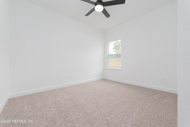 carpeted empty room with a ceiling fan and baseboards