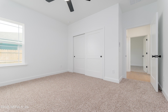 unfurnished bedroom with baseboards, visible vents, a ceiling fan, carpet flooring, and a closet