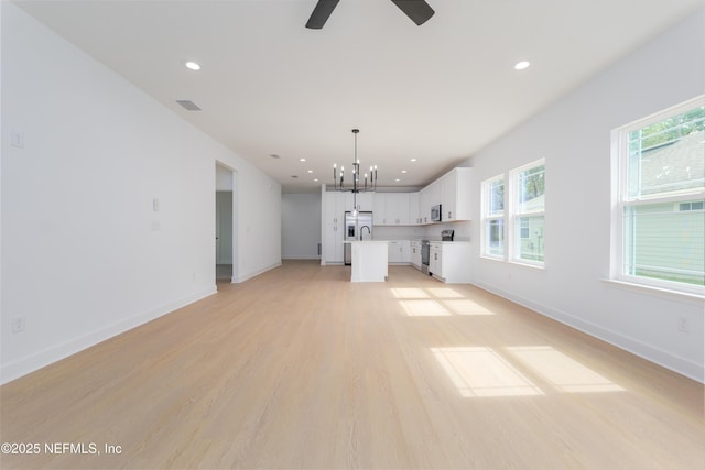 unfurnished living room featuring recessed lighting, visible vents, light wood-style flooring, and baseboards